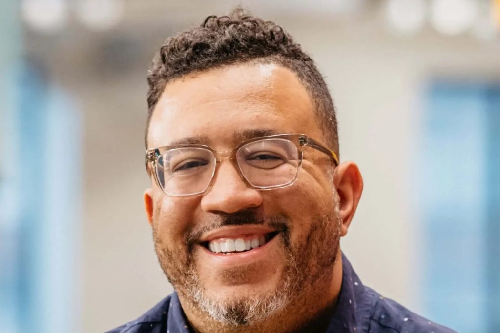Stanley Tate smiling in a navy button-down shirt