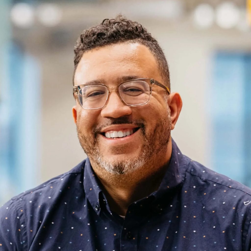 Stanley Tate smiling in a navy button-down shirt