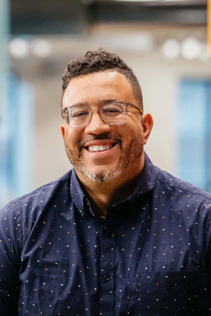 Stanley Tate smiling in a navy button-down shirt